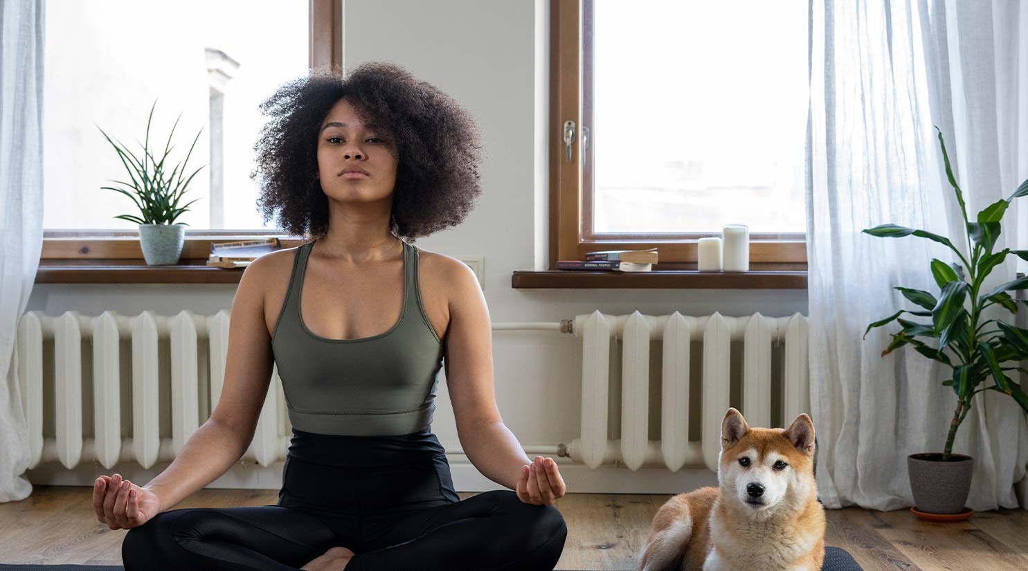 Woman doing Yoga with Dog at her Side
